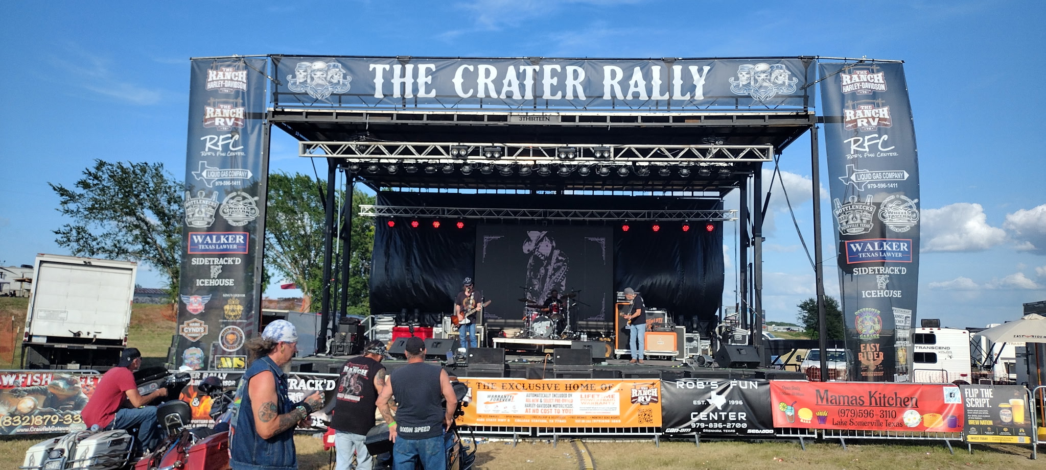 Outdoor event lighting rig at night with crowd